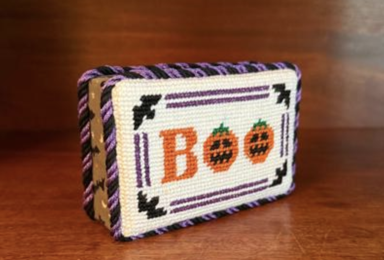 Customer's stitched BOO needlepoint finished as a standing piece with purple and black trim